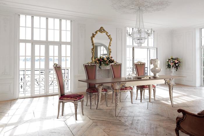 Sala da pranzo luminosa con tavolo allungabile, sedie bordeaux e specchiere