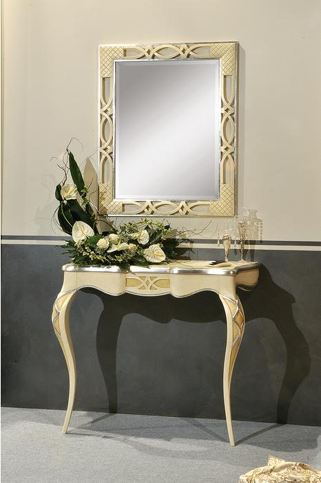 Specchiera con cornice in foglia oro sopra una console laccata